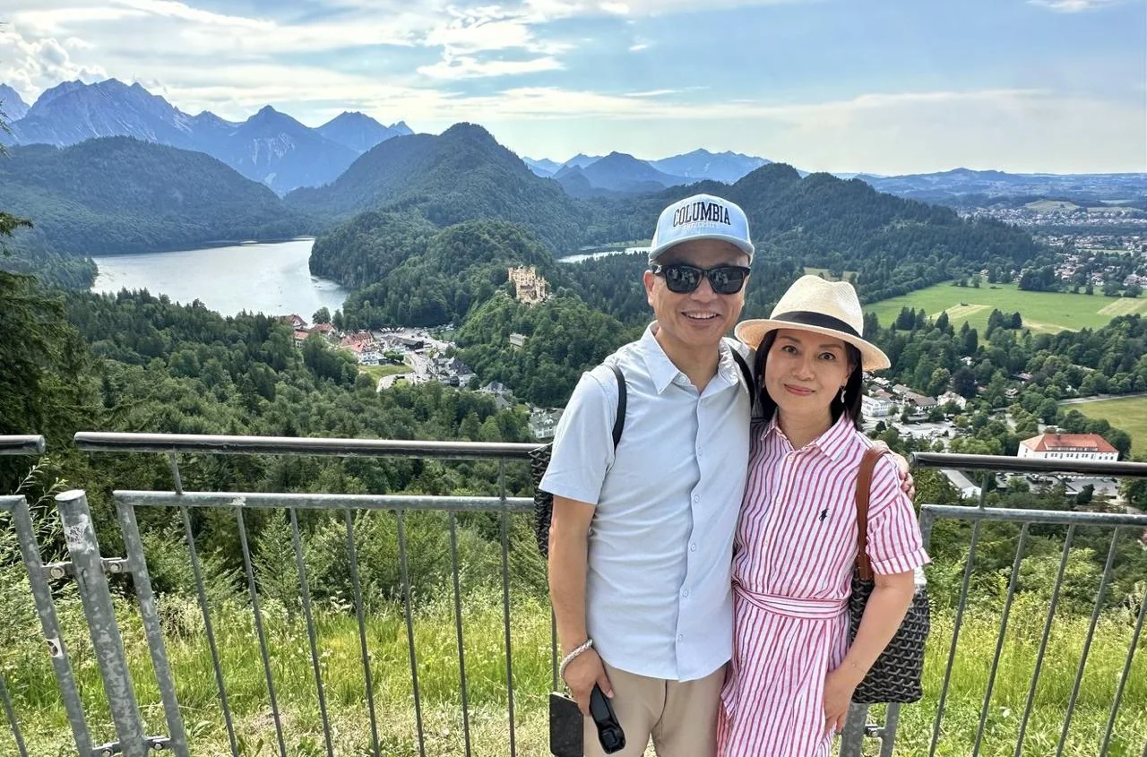 Couple at a viewpoint above Alpsee and the Bavarian mountains