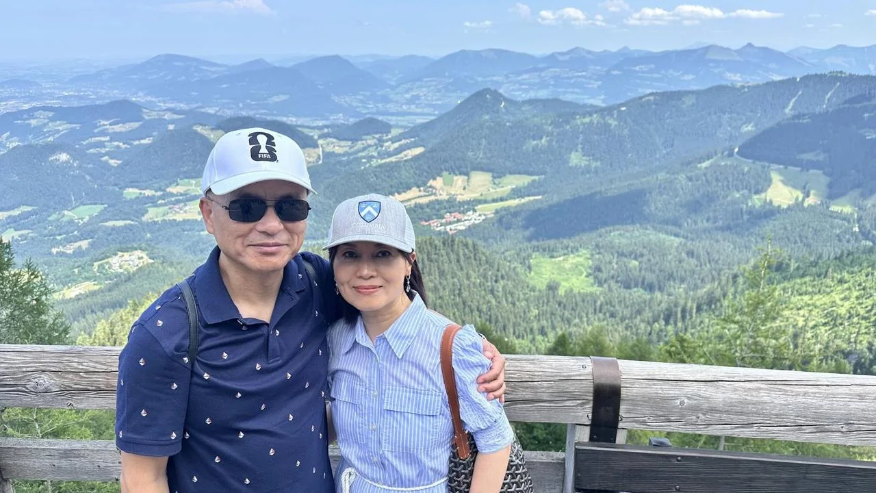 Couple with the alpine valley behind them at the Eagle's Nest