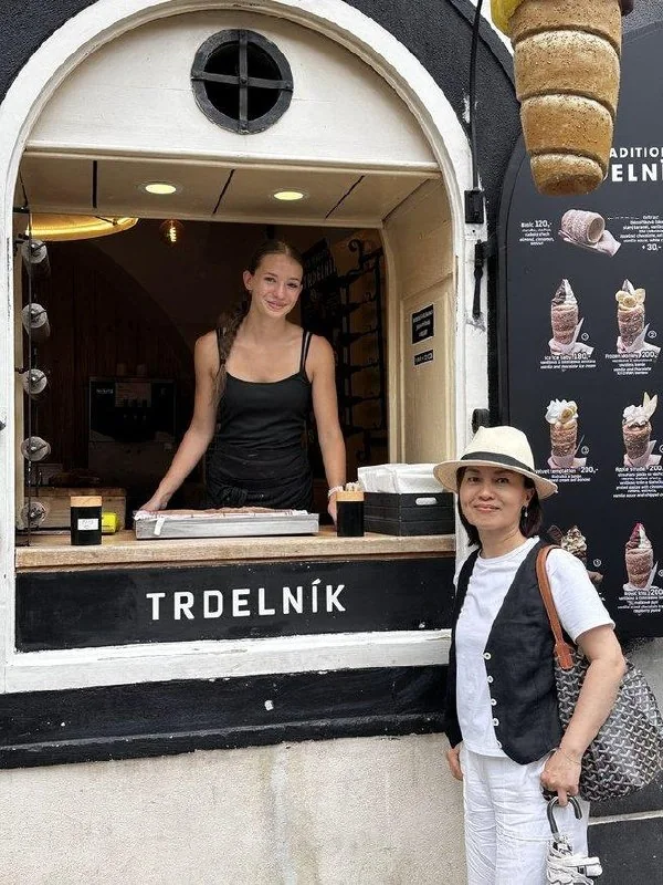 Traveler buying trdelník from a shop window in Český Krumlov