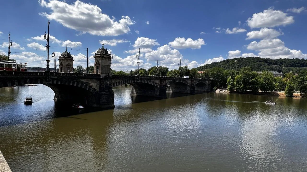 Vltava River and historic bridge under a bright summer sky