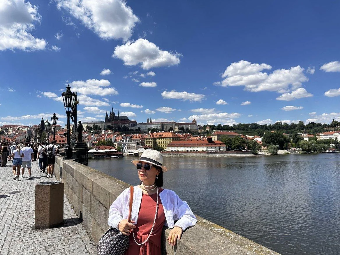Traveler walking on Charles Bridge with Prague Castle beyond