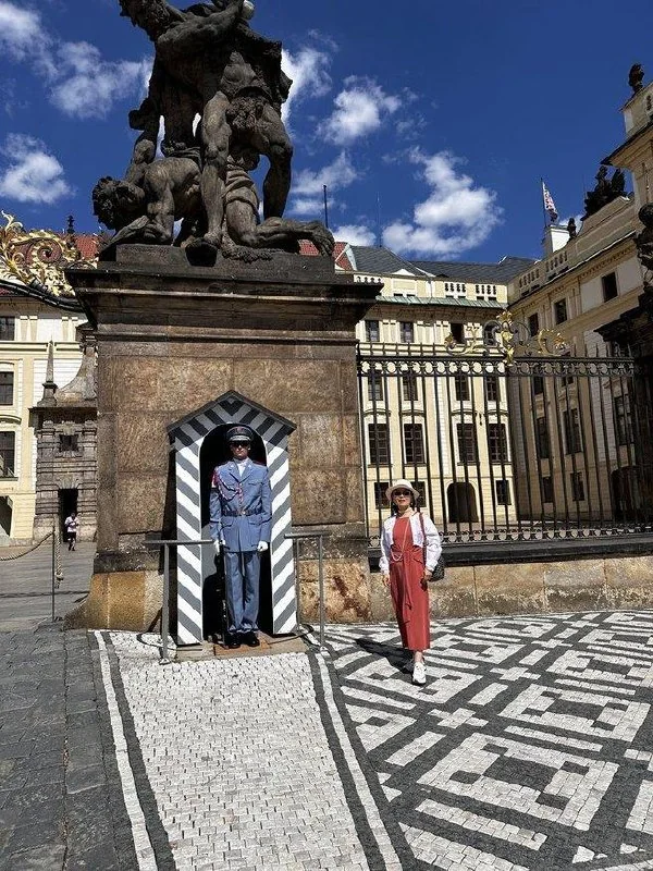 Traveler beside a ceremonial guard at Prague Castle