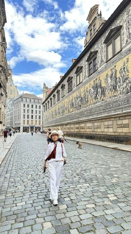 Traveler beside Dresden's long Procession of Princes mural