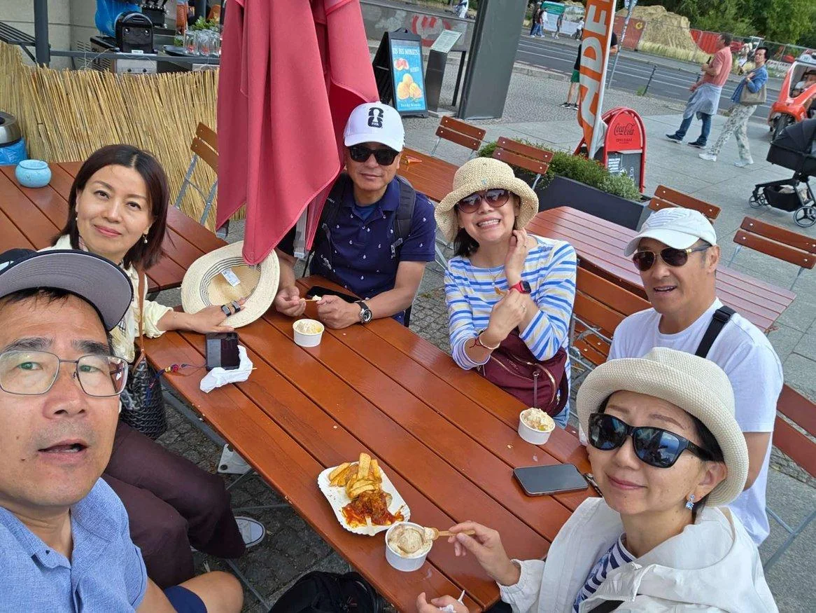 Friends gathered around an outdoor table in Berlin